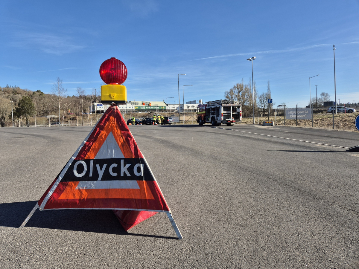 Bild på varningstriangel framför en trafikolycka. På triangeln står "Olycka".
